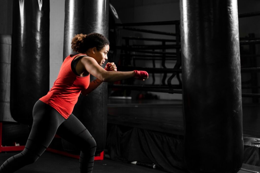 side-view-athletic-woman-training-boxing-center_23-2148416627